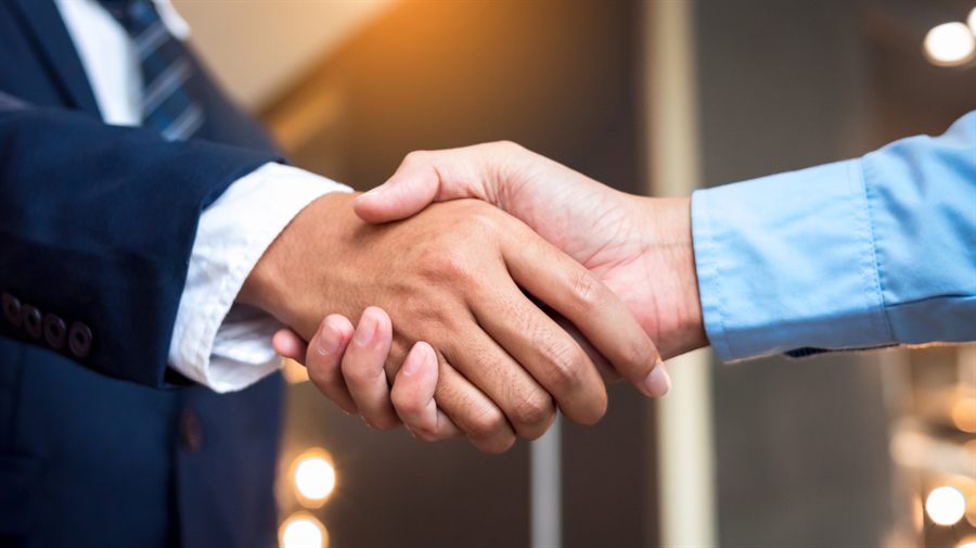 Two people shaking hands to close a deal