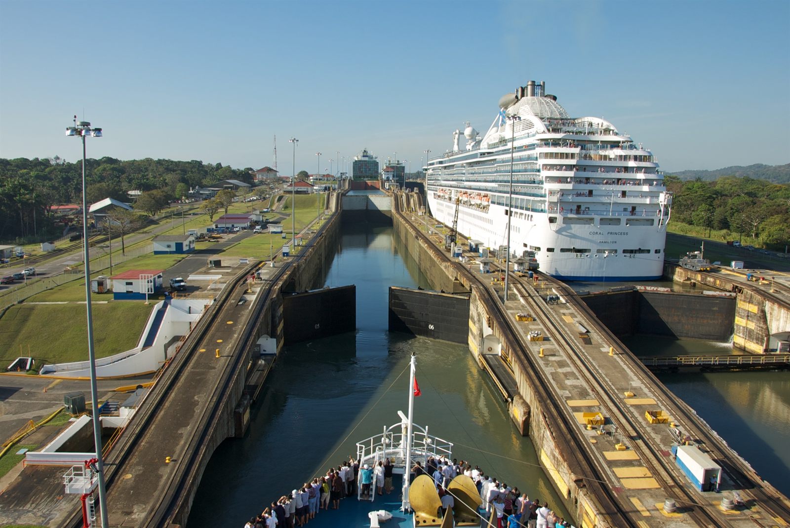 Passengers on a ship bow watching another cruise ship in a Panama Canal lock